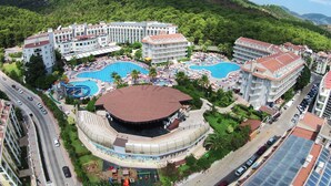 A resort with multiple swimming pools, a central amphitheater, and a mountainous backdrop. - Green Nature Resort & Spa (Marmaris)