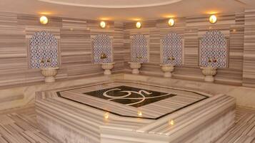 A marble-floored bathroom with ornate wall panels and a central decorative feature.