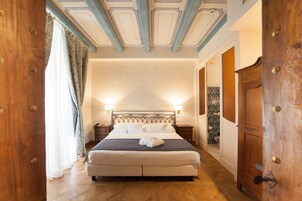 Un dormitorio con una cama grande, armario de madera y techo con molduras decorativas.