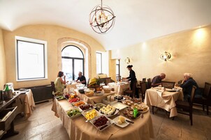 Comedor con varias mesas dispuestas para un bufé, que ofrece una variedad de alimentos y un candelabro.