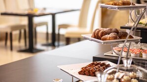 A buffet setup with various pastries and desserts on tiered serving trays.