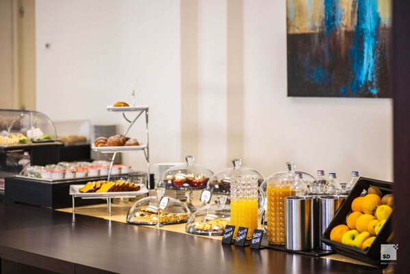 A buffet with various food items and beverages, including pastries, fruits, and juices. - Hotel Regina Elena 57 & Oro Bianco Spa (Rimini)