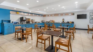 Un restaurant moderne avec des meubles de couleur bleue, des tables en bois et un sol carrelé.