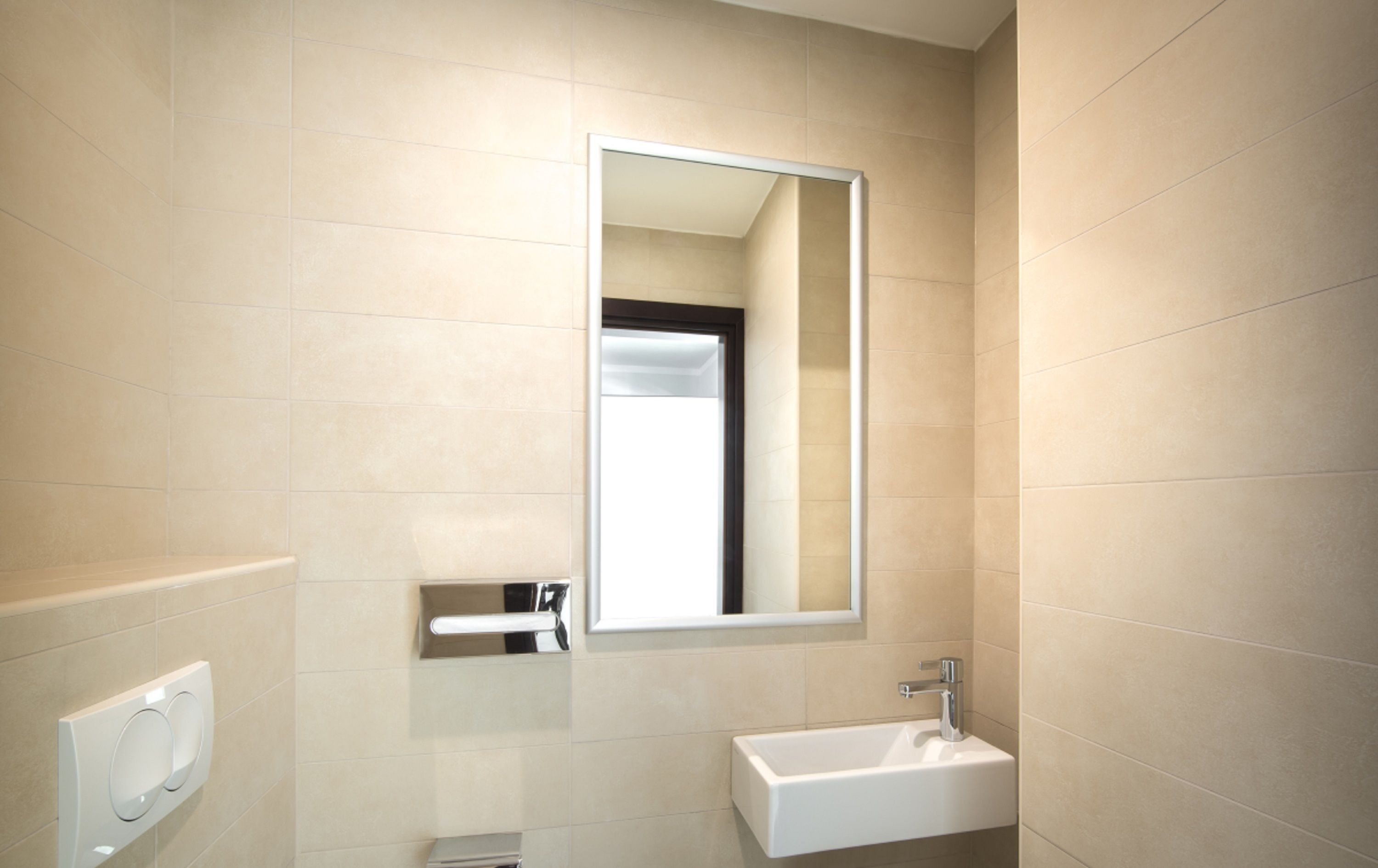 A bathroom with a white sink, a mirror, and a towel rack.