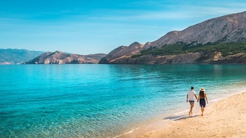 En la playa, camastros, sombrillas y toallas de playa 