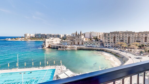 A coastal cityscape with a prominent church, a marina, and modern buildings. - St Julian's Bay Hotel (St. Julian's)