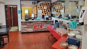 A restaurant interior with a waffle display, a juice dispenser, and a sign reading "OMAK INN".