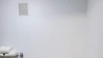 Baño estándar con inodoro, barra de apoyo y toallero.