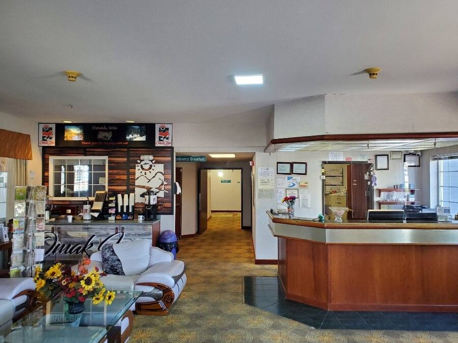 Un vestíbulo de hotel con una recepción, zona de estar y una estación de café.