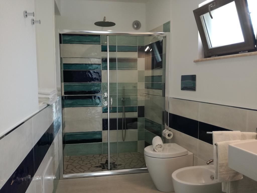 Un baño moderno con cabina de ducha de vidrio, inodoro y lavamanos.