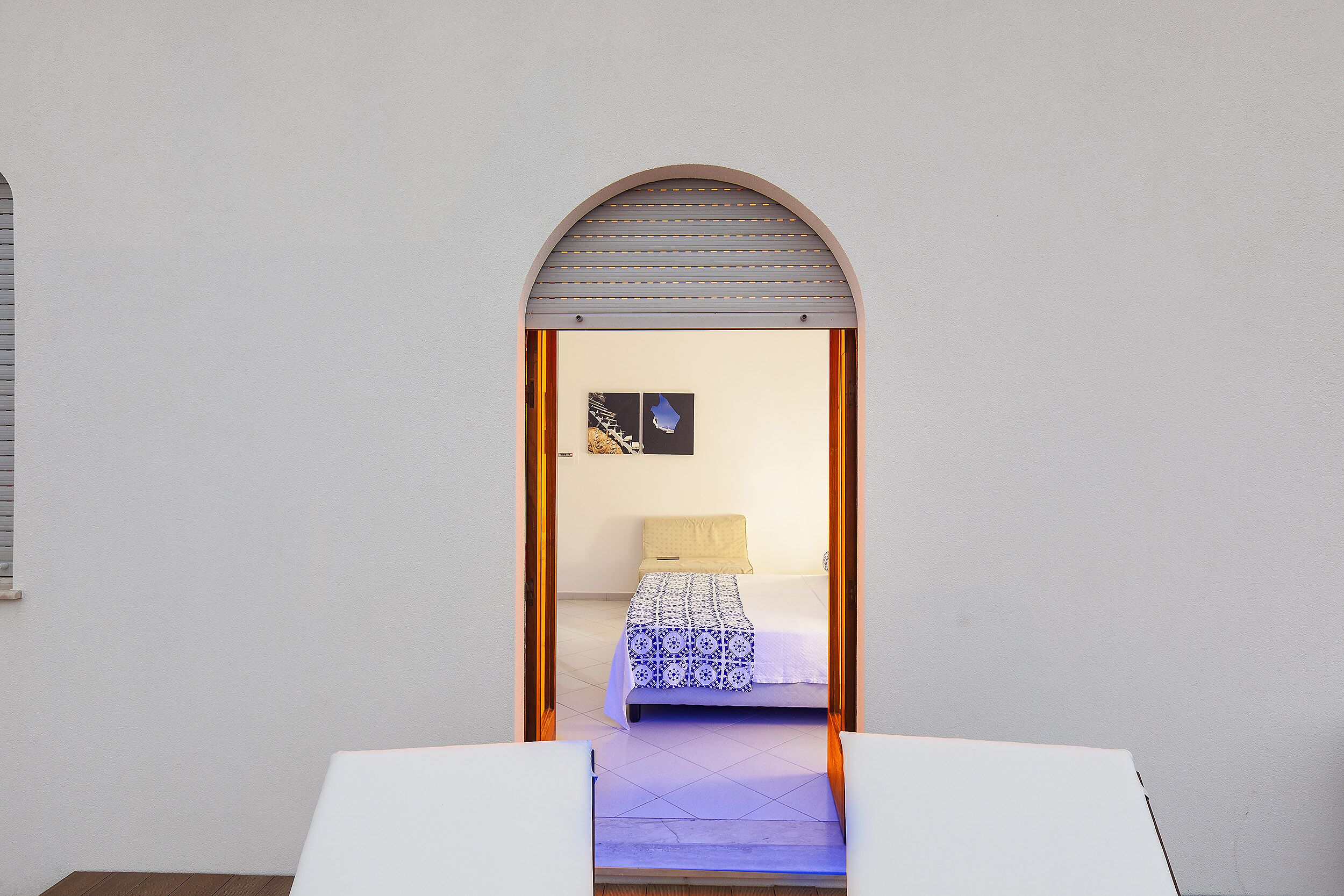 A bedroom with a bed, a window, and a door.