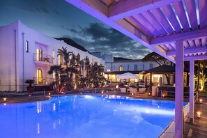 Una piscina al aire libre de temporada, sombrillas