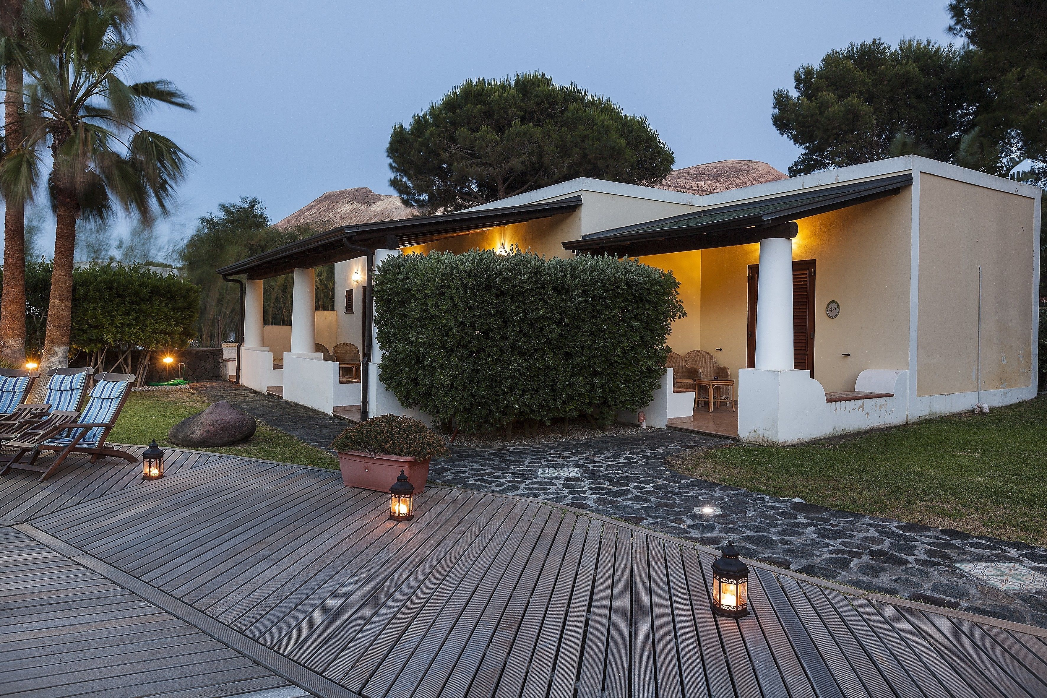 Una casa moderna con un patio, mobiliario exterior y un camino de piedra.