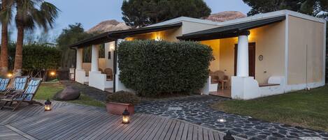 Una casa moderna con un patio, mobiliario exterior y un camino de piedra.