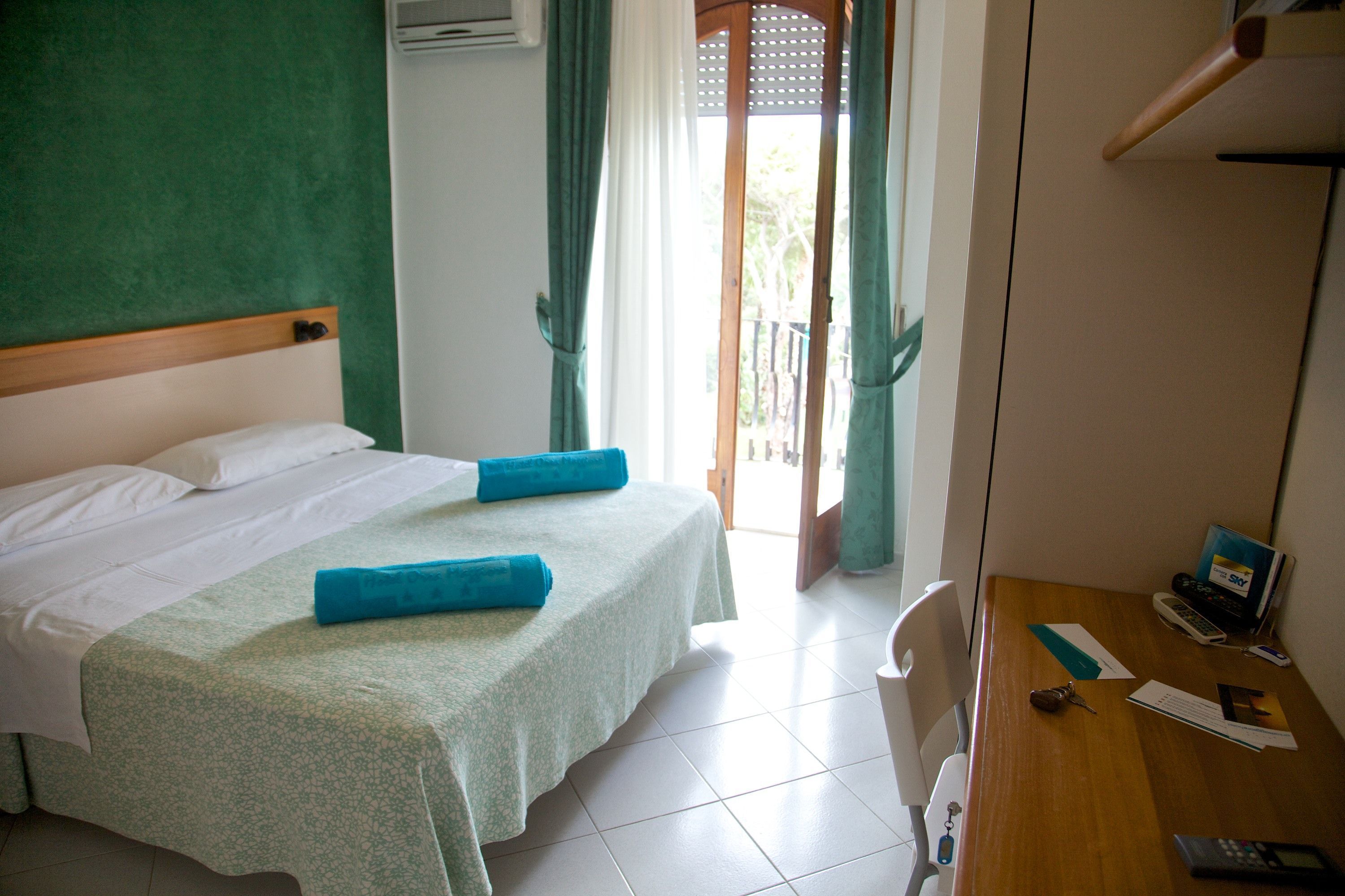 Una habitación de hotel con una cama, un escritorio y una silla.