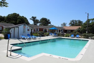 Una piscina al aire libre de temporada, sombrillas