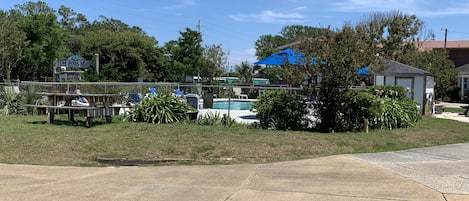 Un estacionamiento con piscina, una cerca y un letrero del Motel Cape Pines.