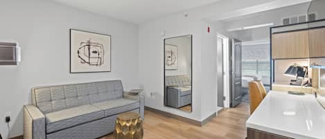 Una sala de estar moderna con un sofá gris, una mesa de centro y obras de arte en las paredes.