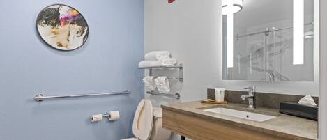 A modern bathroom with a toilet, sink, and towel rack.