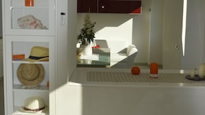 Ein modernes Interieur mit einer weißen Regaleinrichtung, einem Glastisch mit dekorativer Tischläufer und einem weißen Sofa im Hintergrund.