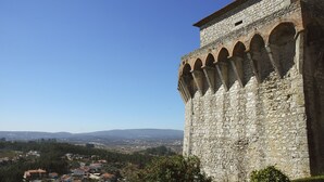 Una torre de piedra con ventanales de arco y una vista despejada de un pueblo abajo.