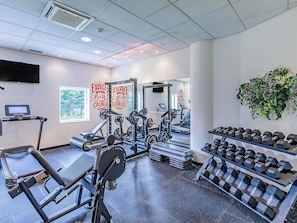 A gym with exercise equipment, treadmills, and dumbbells. - ibis Lisboa Alfragide (Amadora)