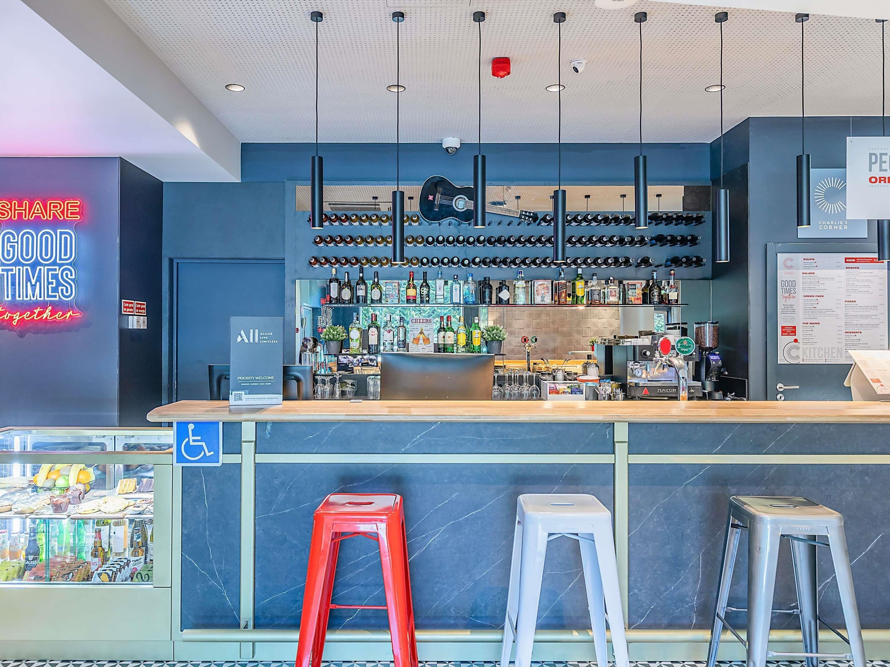 Un espace bar comprenant un comptoir, des tabourets et une variété de bouteilles et de verres.