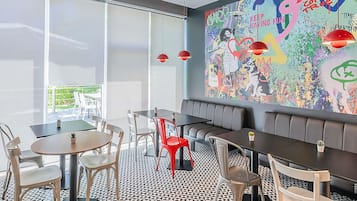 Un interior moderno con un gran mural abstracto, una variedad de opciones de asiento y un suelo con estampado geométrico.