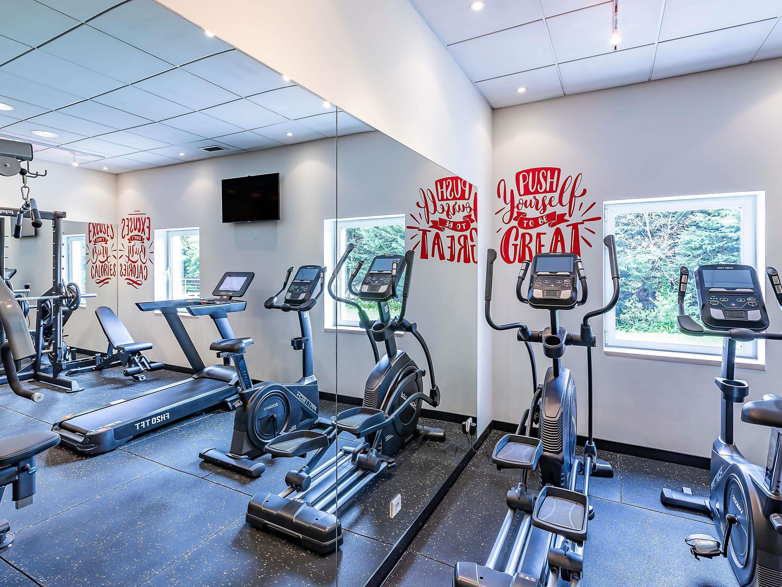 A gym with treadmills, elliptical machines, and weight equipment.