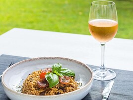 A plate of food with a glass of wine on a table.