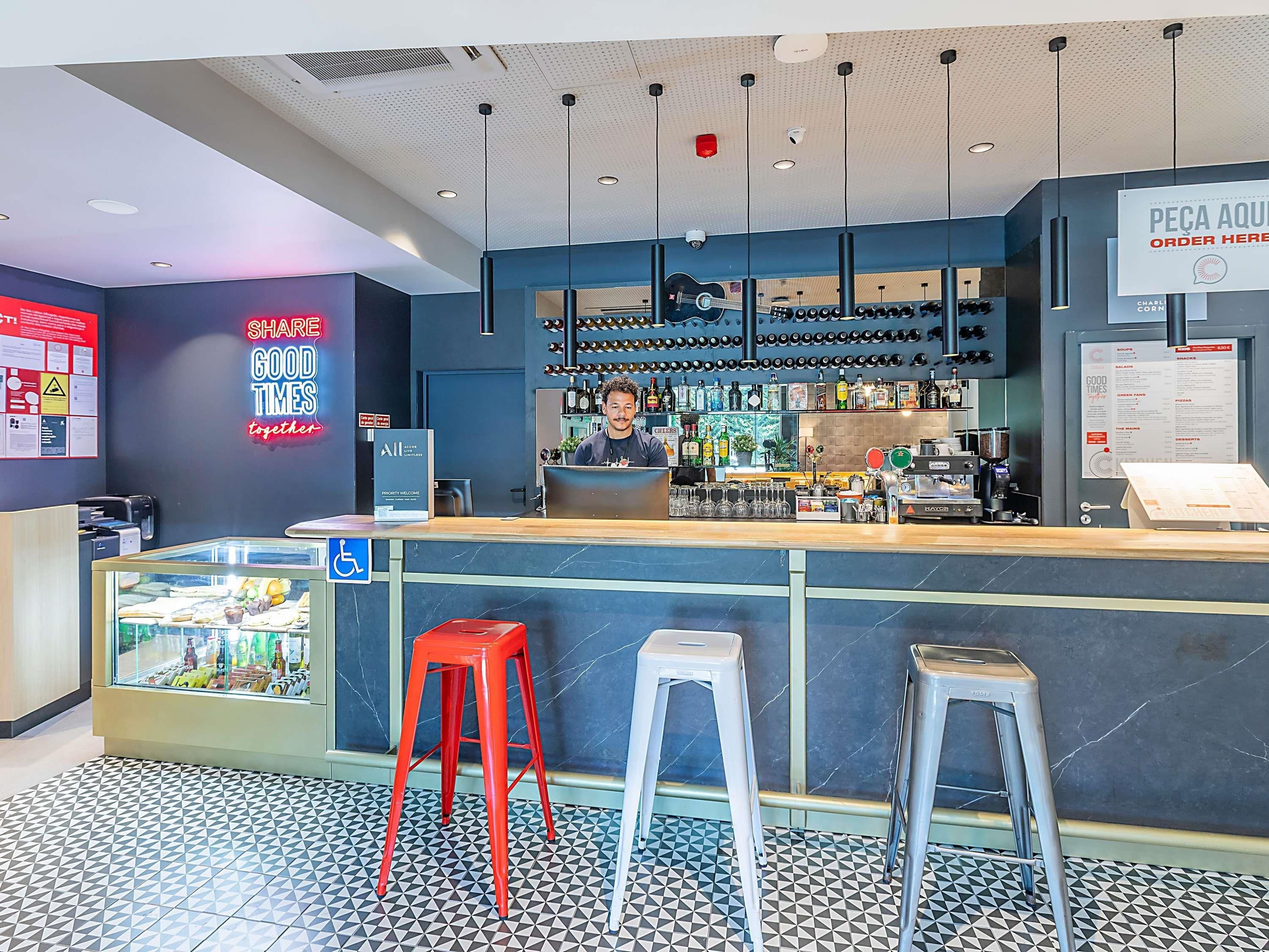 A bar area with a counter, stools, a glass display case, and a menu board.