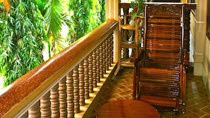 A wooden staircase with a balustrade leading to a balcony with a view of lush greenery. - Shining Angkor Boutique Hotel (Siem Reap)