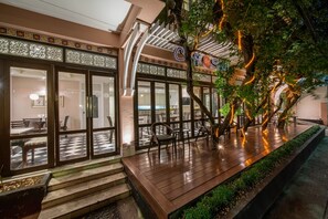 A restaurant with a checkered floor, outdoor seating, and a decorative tree with lights. - La Petite Salil Sukhumvit 8  (Bangkok)