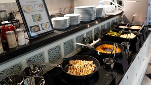 Montaje de bufé con diversas opciones de comida, incluyendo un letrero que indica las variedades de huevo, y múltiples utensilios y platos para servir.