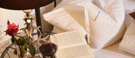 Una cama con almohadas blancas y un libro encima.