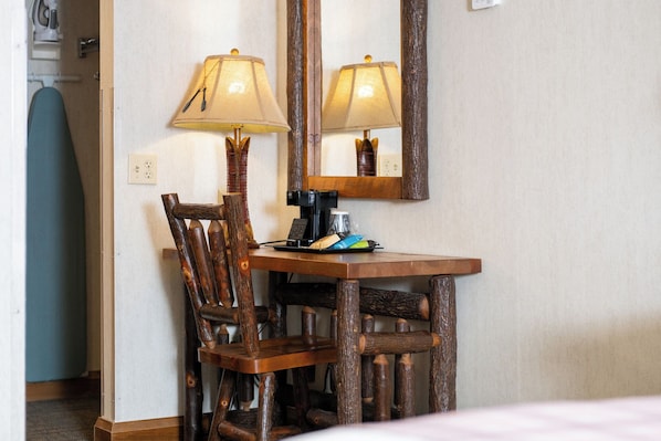 Un escritorio de madera con una silla, una lámpara y una cafetera.