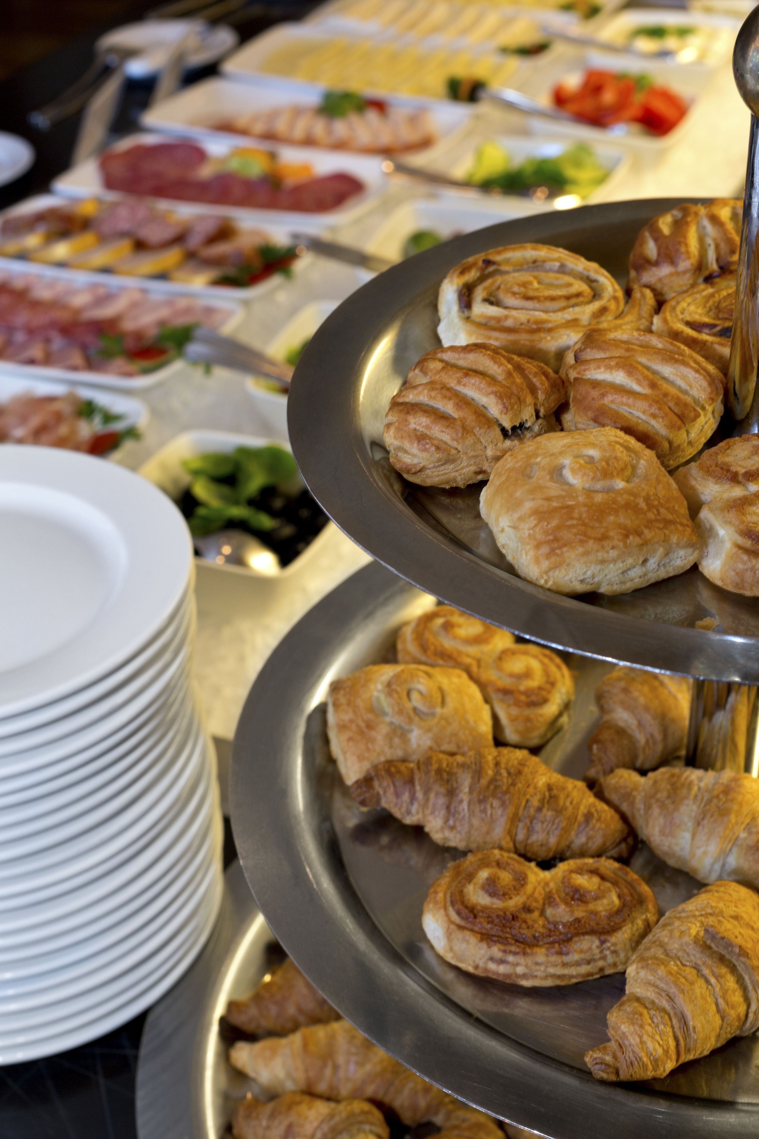 Un buffet proposant une variété de plats, notamment des pâtisseries et des salades.