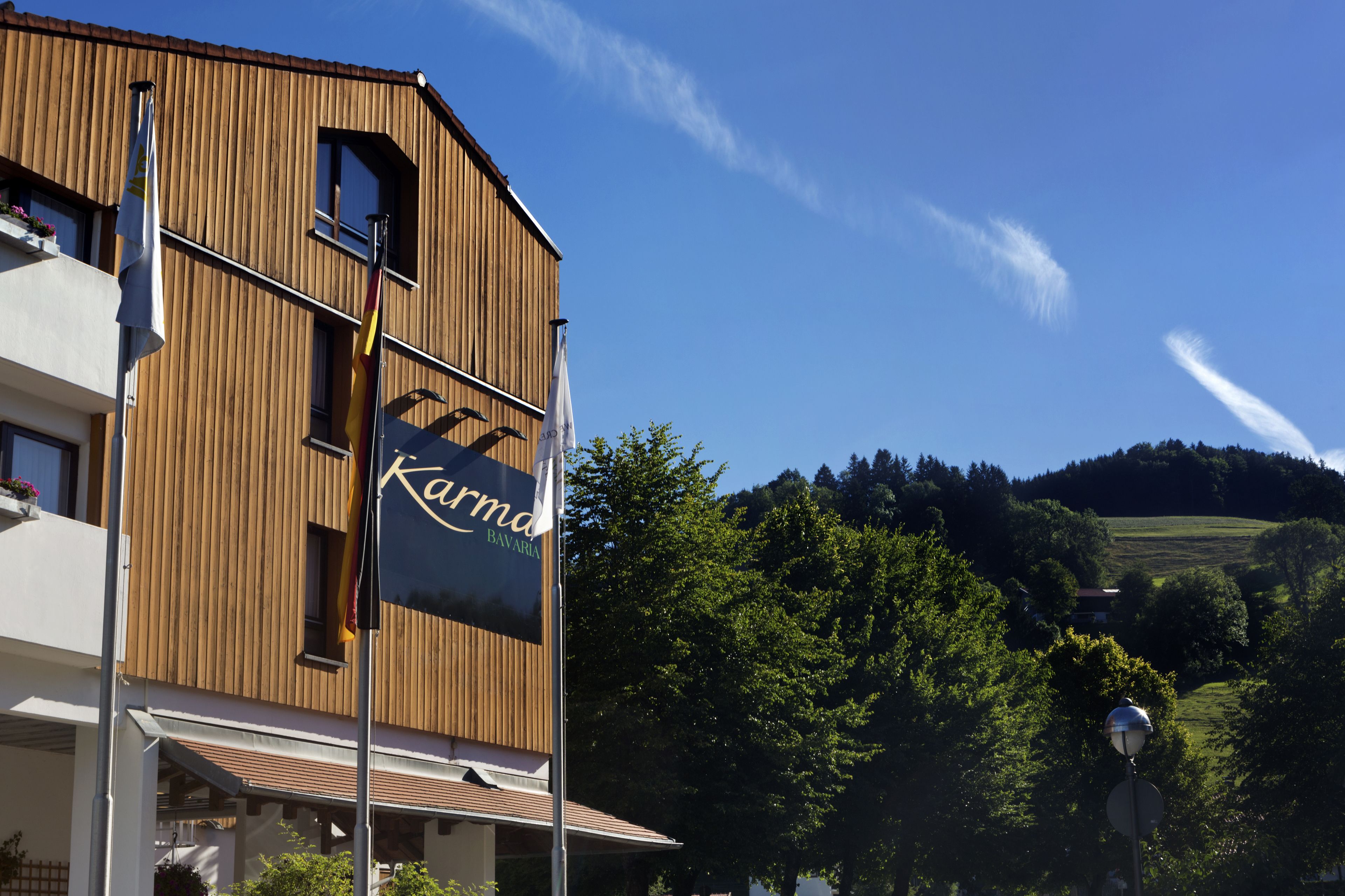 A building with a wooden facade and a sign that reads "Karma Bavaria."