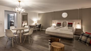 Een moderne hotelkamer met een groot bed, een bureau, een eettafel en een kroonluchter.