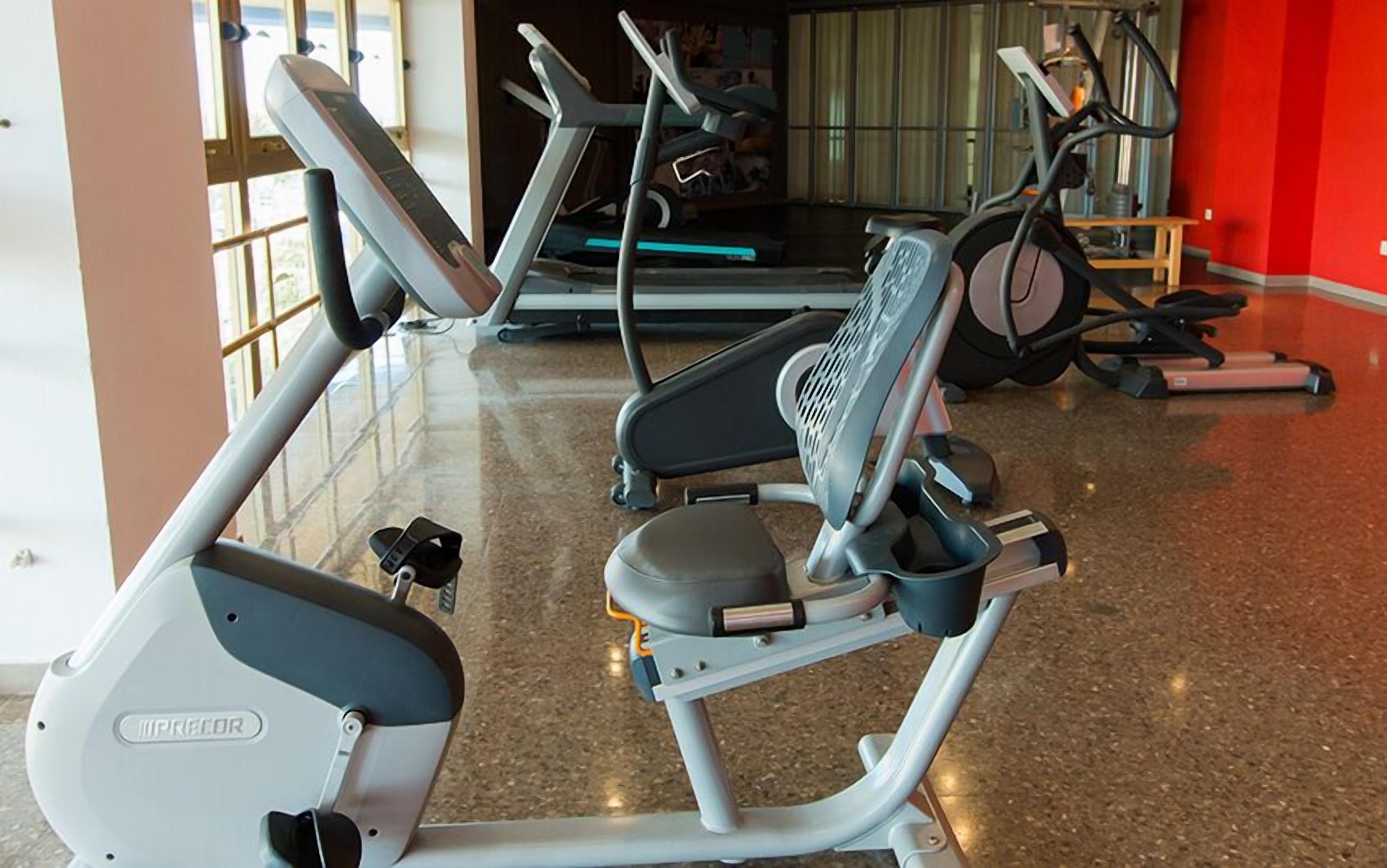 A gym with various exercise machines, including treadmills and elliptical trainers.