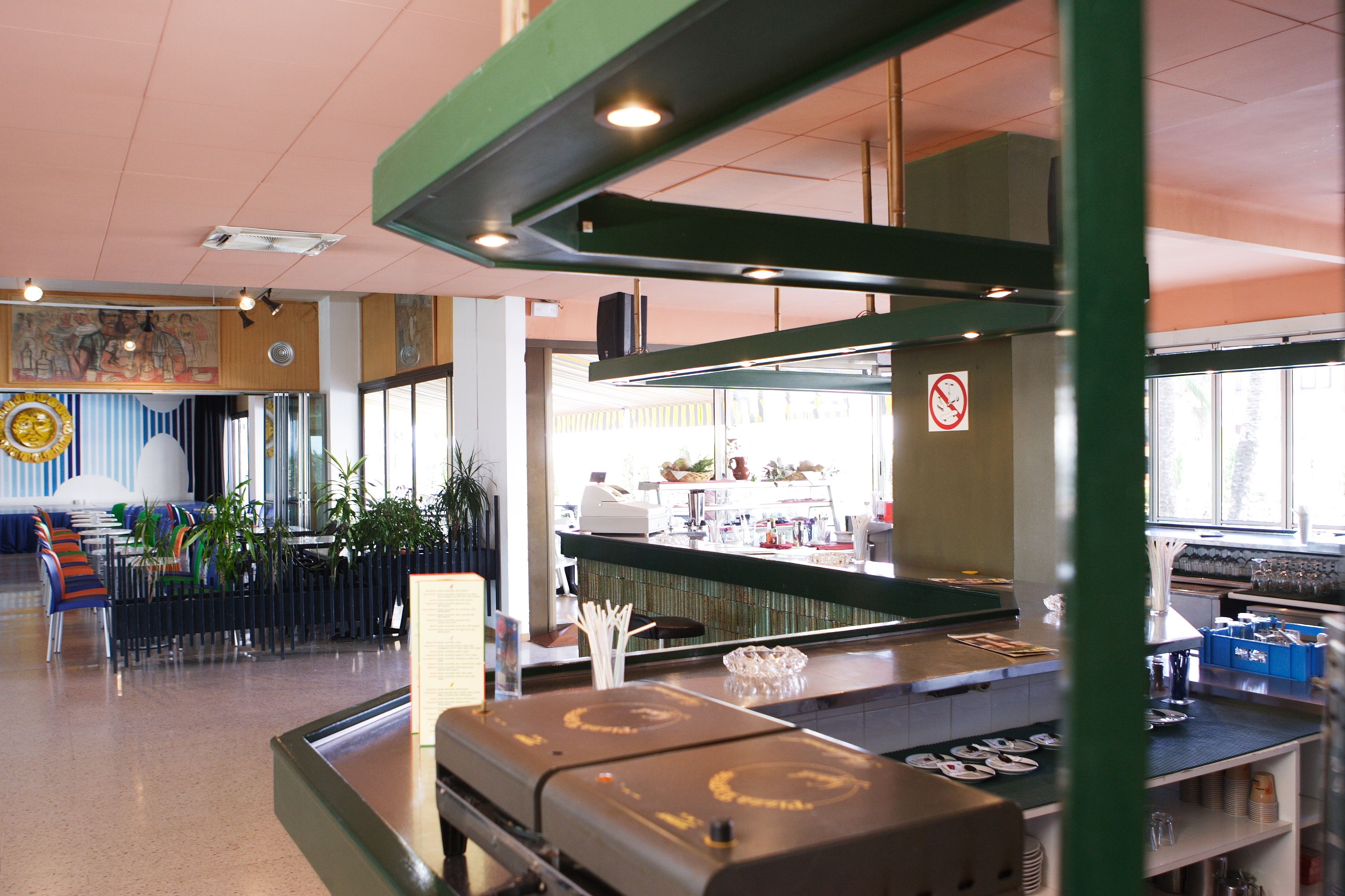 A restaurant interior with a bar area, seating, and a counter.