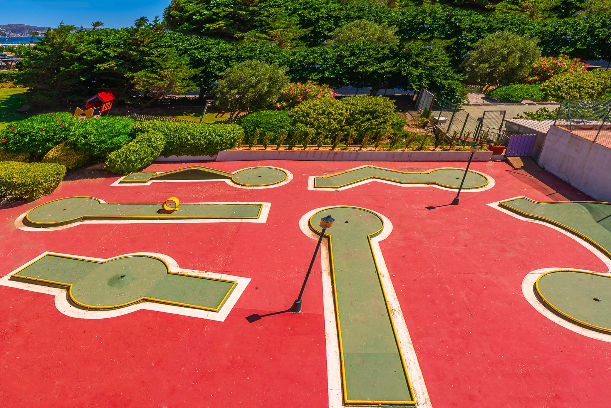 A red and green golf putting green with a keyhole hole design.