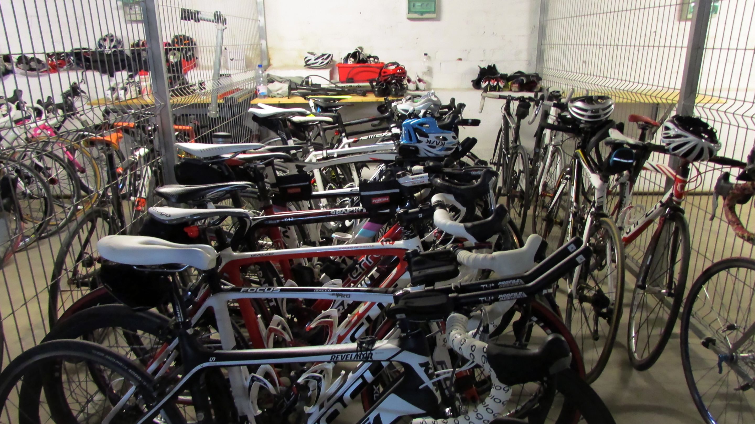 A bicycle storage area with multiple bicycles secured in a rack.