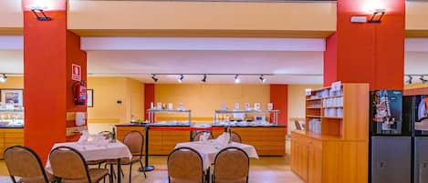 A restaurant with a high ceiling, a counter with a coffee machine, and a buffet area.