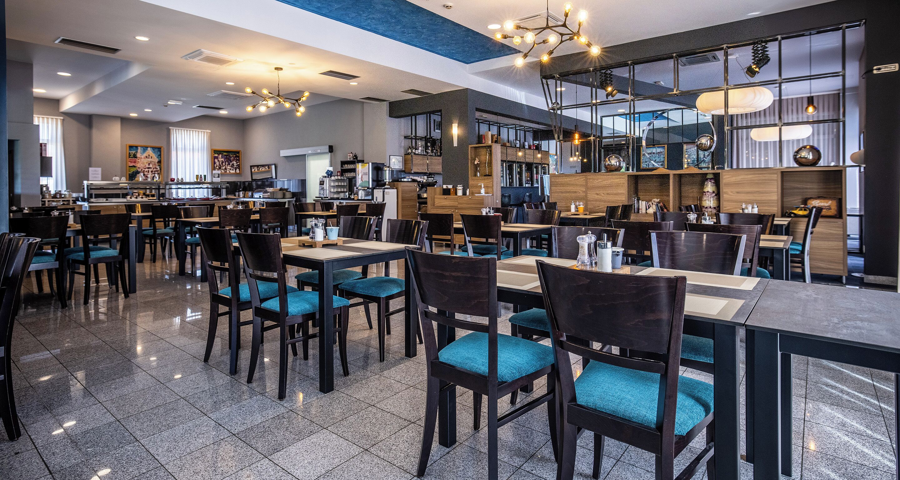 A modern restaurant with multiple dining areas, including a bar and a buffet.