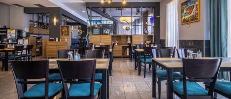 A modern restaurant with multiple dining tables and chairs, a bar area, and a view of the city through large windows.