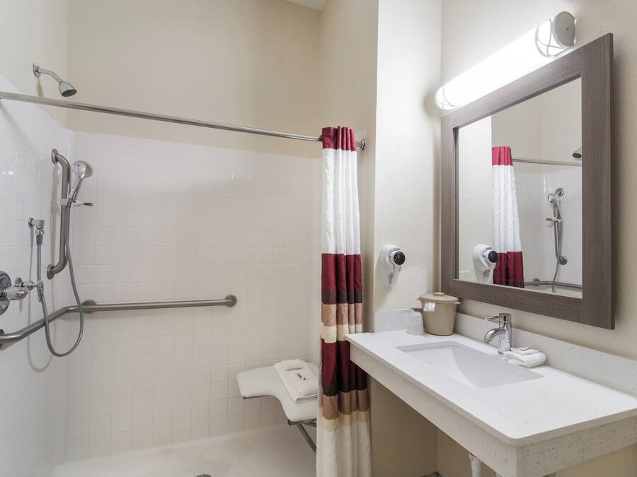 Ein Badezimmer mit Dusche, Toilette, Waschbecken und Spiegel.