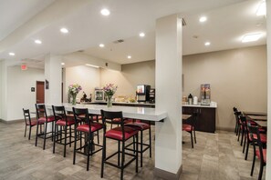 A clean, modern restaurant with a bar area, multiple seating options, and a visible exit sign. - Red Roof Inn Panama City (Panama City)