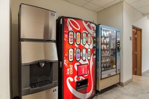Máquina expendedora con el logotipo de Coca-Cola y un botón para dispensar artículos.