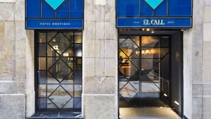The entrance to Hotel Boutique and El Call with blue-tinted windows and a stone facade. - Hotel El Call (Barcelona)